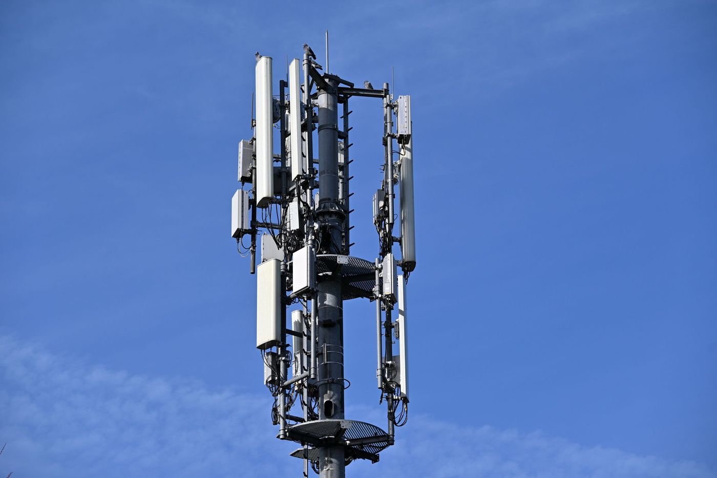 Antennas and radio equipment on a telecom tower against a blue sky